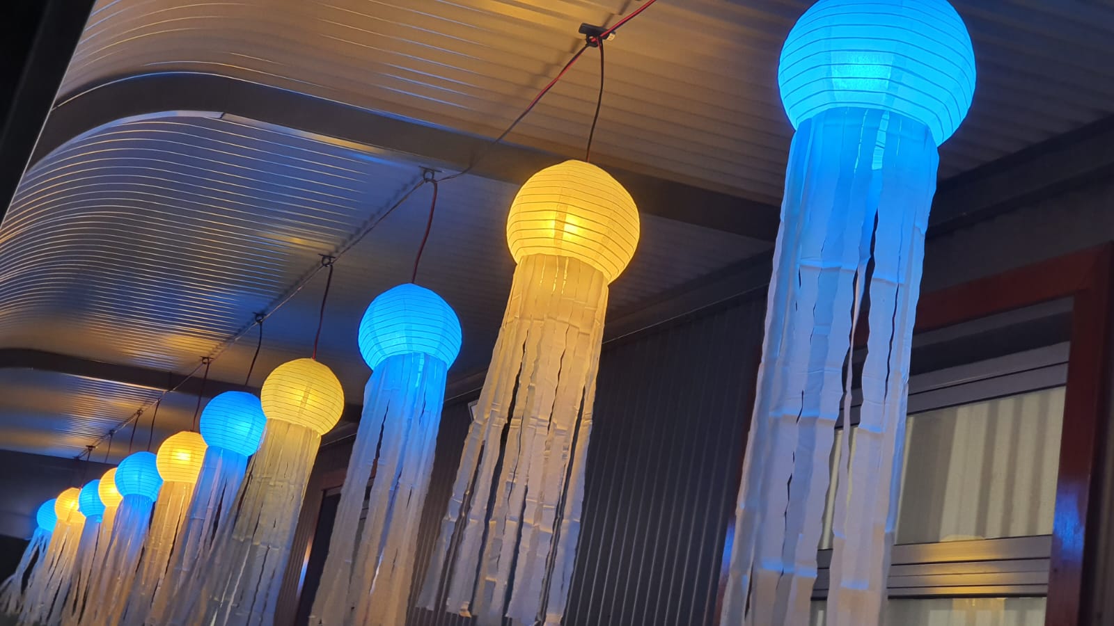 Blue and yellow lanterns hanging in a row during a lantern festival.